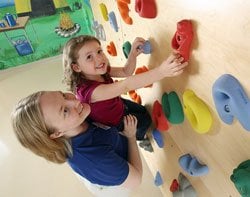 Girl receiving assistance on the climbing wall