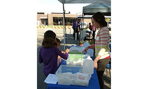 Kelsey King, APRN, CNP, helps young community members learn about safety while making first aid kits at the Monticello Farmers’ Market.